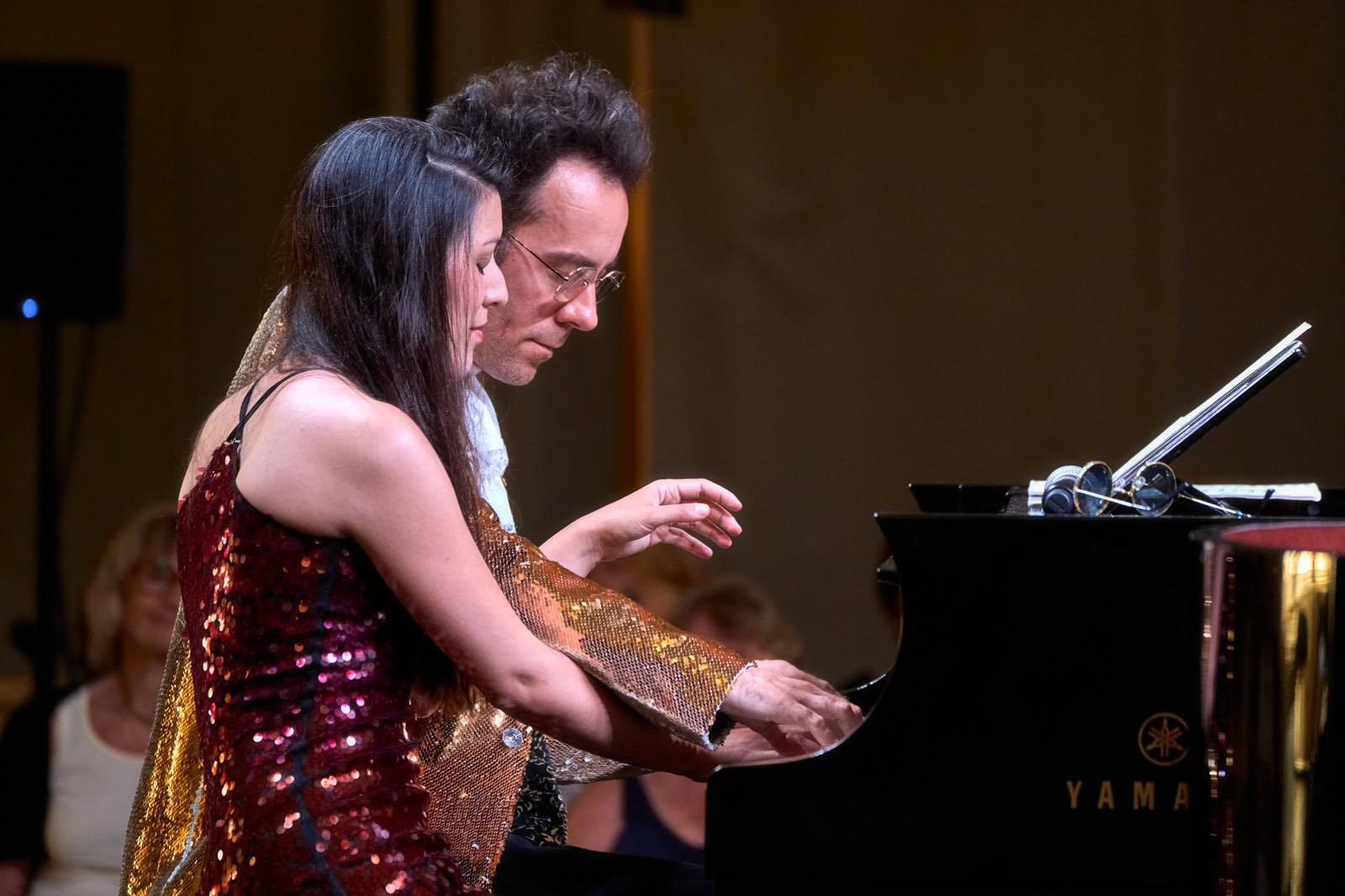 Louise et Dexter en tenues à paillettes jouent à quatre mains sur scène